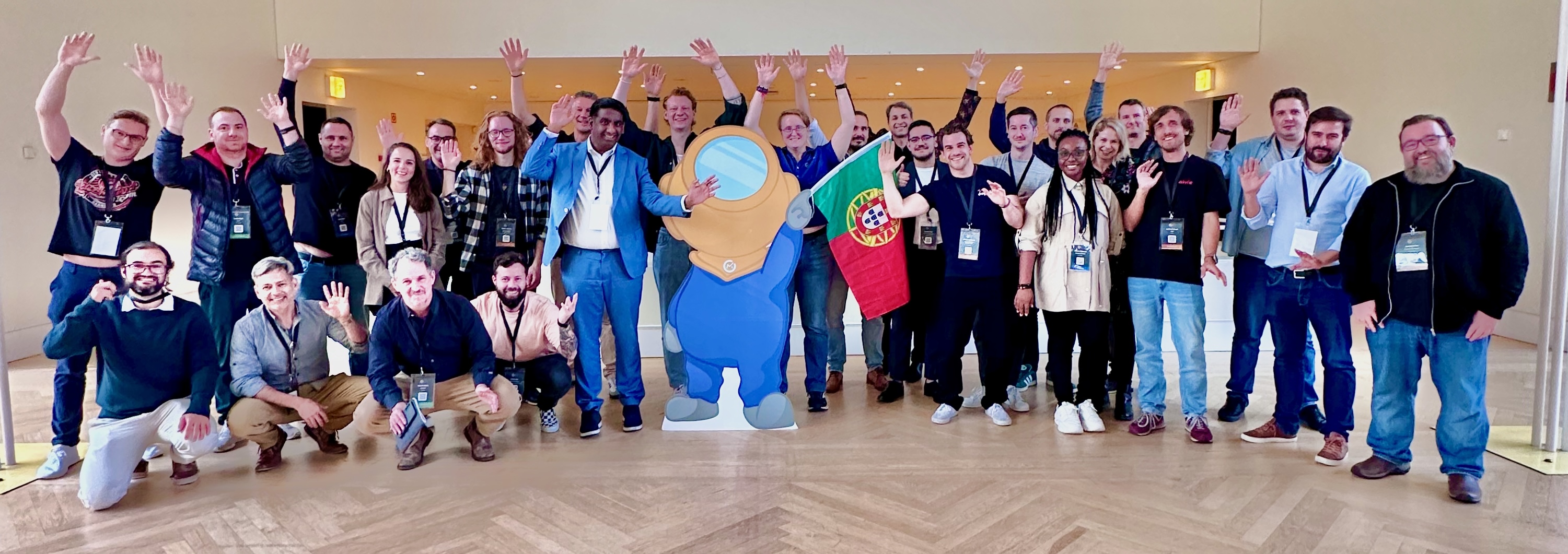 Photo of mauticians in a room with a cutout of the Mautinaut in the middle waving the portuguese flag