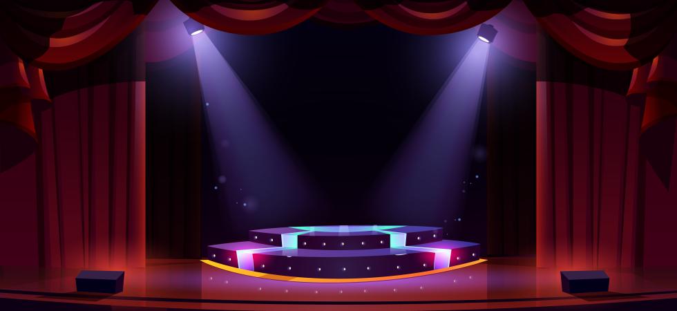 Photo of a theatre stage with red curtains pulled back and two spotlights shining onto the centre of the stage which is circular in purple and pink colours.