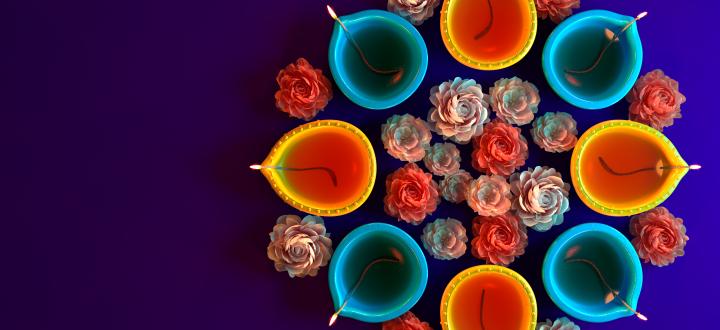 Image of several blue and orange fig-shaped butter lamps arranged with flowers around them and in the middle.