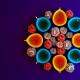 Image of several blue and orange fig-shaped butter lamps arranged with flowers around them and in the middle.