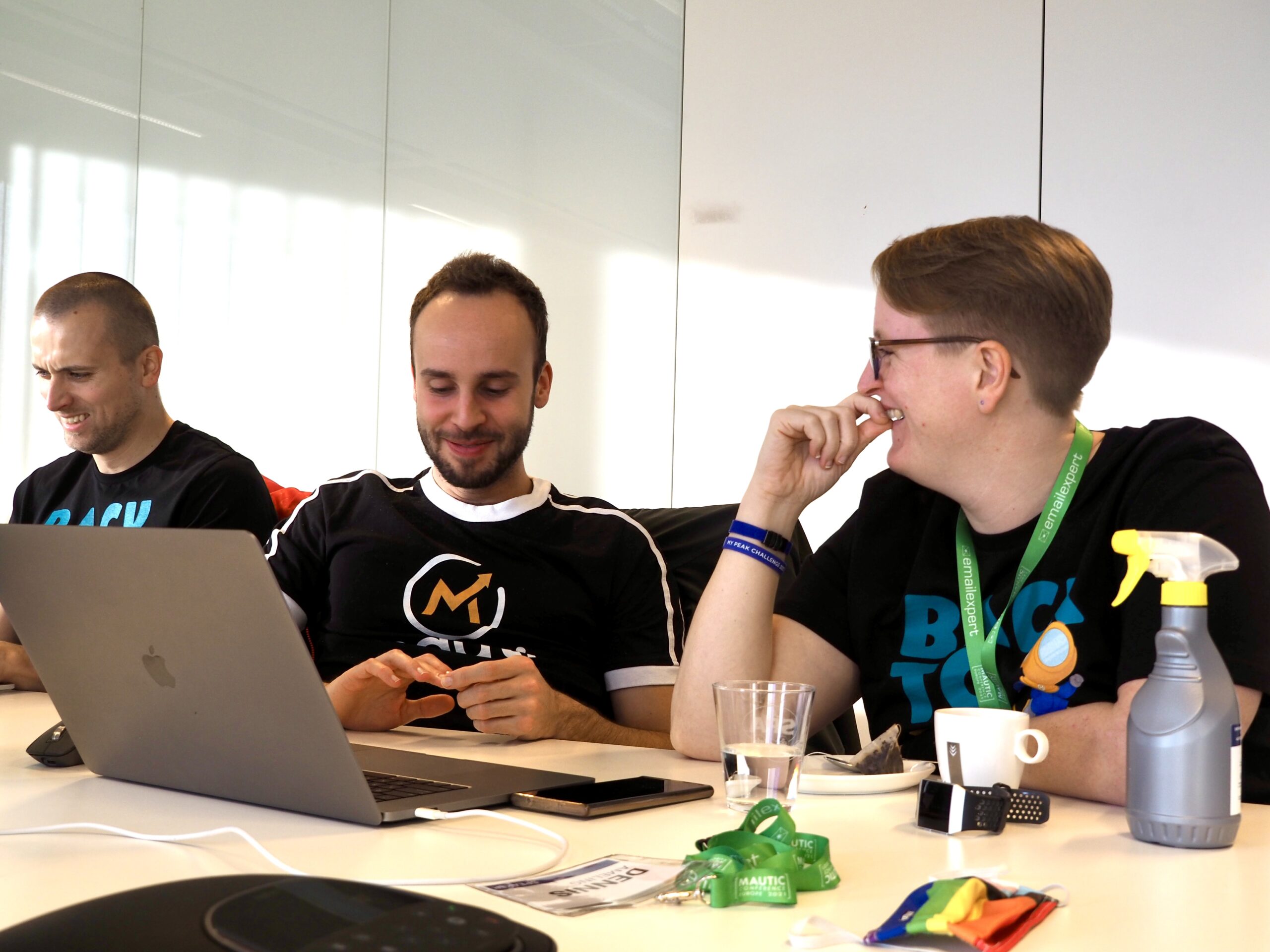 A photo of two people sitting at a table with a laptop working together