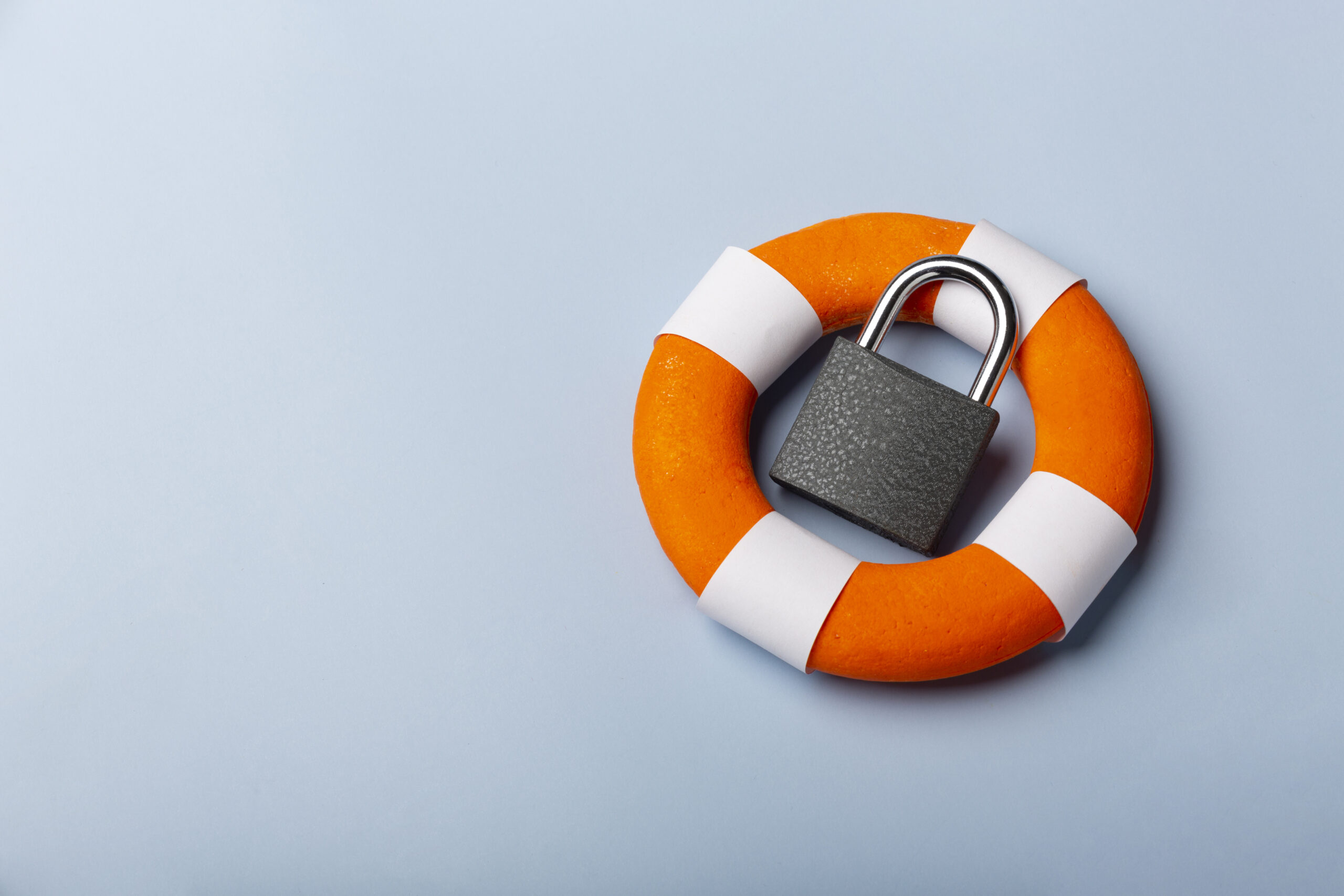 Photo of a lifering with a locked padlock resting inside it on a grey coloured background