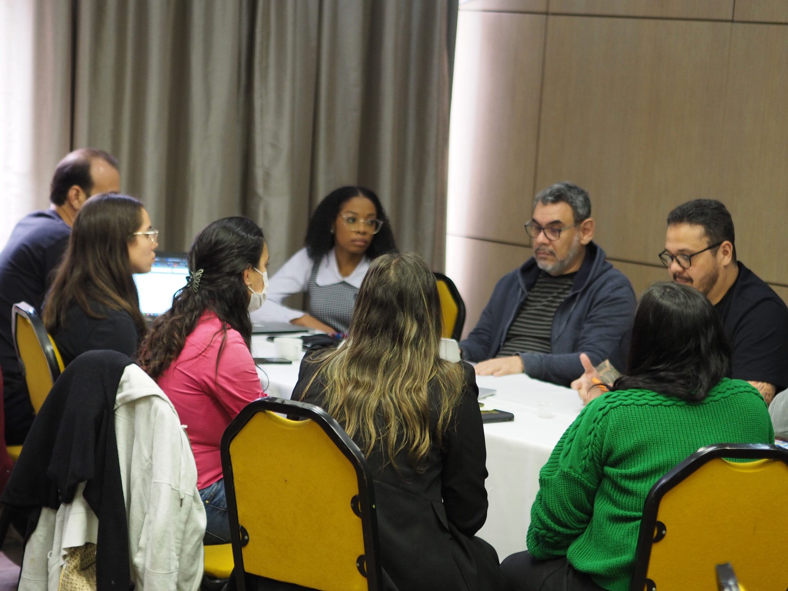 Photo of a diverse group of people sitting around a table collaborating on a project.