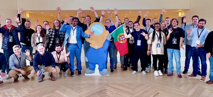 Photo of mauticians in a room with a cutout of the Mautinaut in the middle waving the portuguese flag