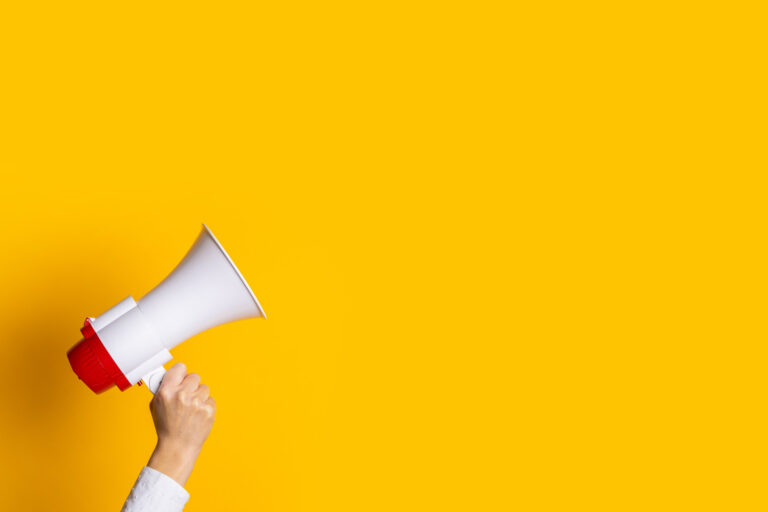 yellow background with a person holding a megaphone