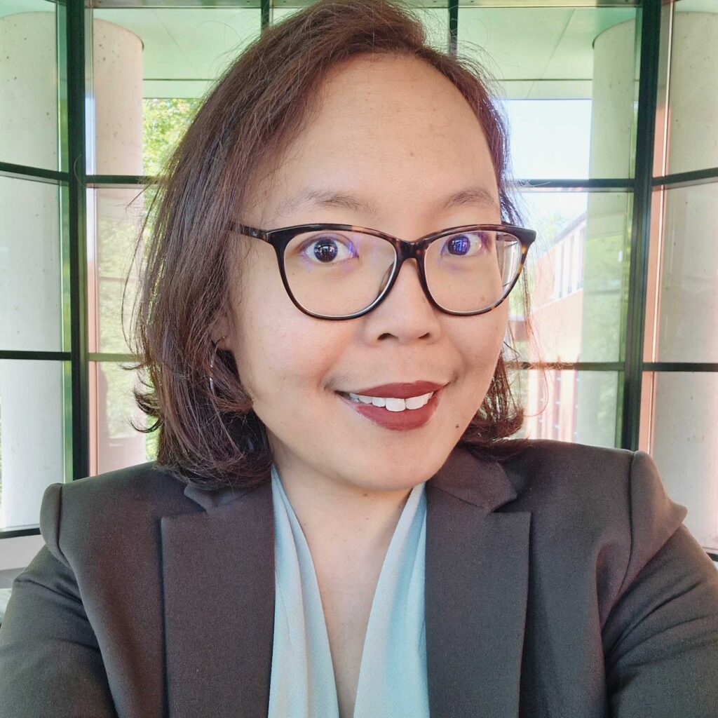Leadership 7 Photo of Ayu Adiati, an Indonesian woman with shoulder length dark hair, wearing dark rimmed glasses and smiling to the camera.