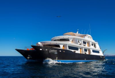 Image of a large powerboat on a calm sea with blue skies behind.